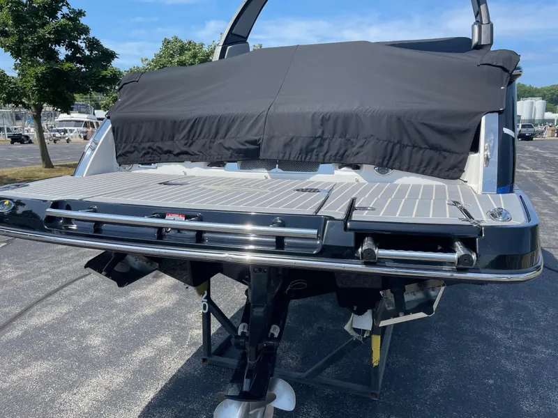 Slide: The Image of 2018 Chaparral 267 SSX boat with covered deck, parked outdoors on a sunny day. - 3