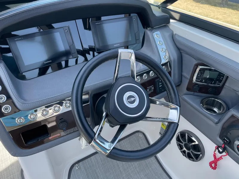 Slide: The Image of 2018 Chaparral 267 SSX boat dashboard with steering wheel and Garmin displays. - 5