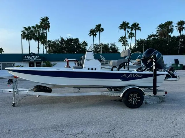 Slide: The Image of 2026 Avid 19 FSX boat on trailer, parked outdoors with palm trees in the background. - 1