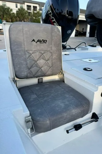 Slide: The Image of Avid 19 FSX 2026 boat seat with gray upholstery and logo, outdoor setting. - 13
