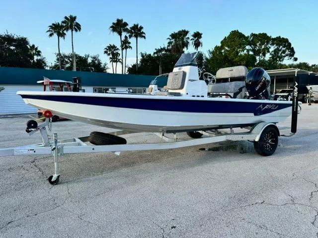 Slide: The Image of 2026 Avid 19 FSX boat on trailer, parked outdoors with palm trees in background. - 2