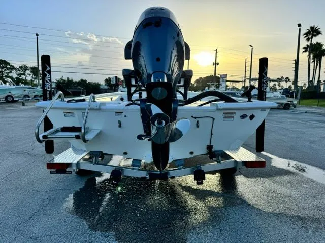 Slide: The Image of Avid 19 FSX boat, 2026 model, rear view at sunset in a parking lot. - 4