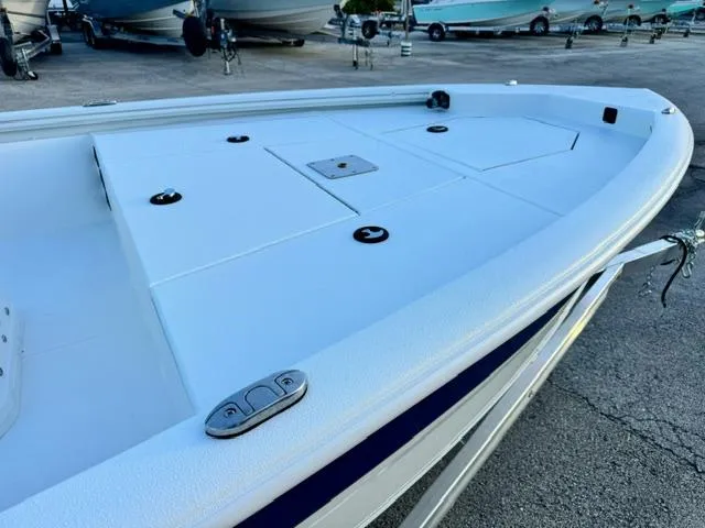 Slide: The Image of 2026 Avid 19 FSX boat deck, white surface, docked with other boats in the background. - 8