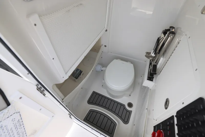 Slide: The Image of Interior of 2026 Sea Hunt Gamefish 27 Coffin Box boat, featuring a compact marine toilet. - 10