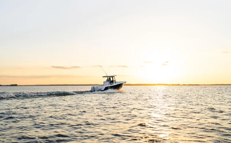 Slide: The Image of 2026 Sea Hunt Gamefish 27 Coffin Box boat cruising at sunset on open water. - 35