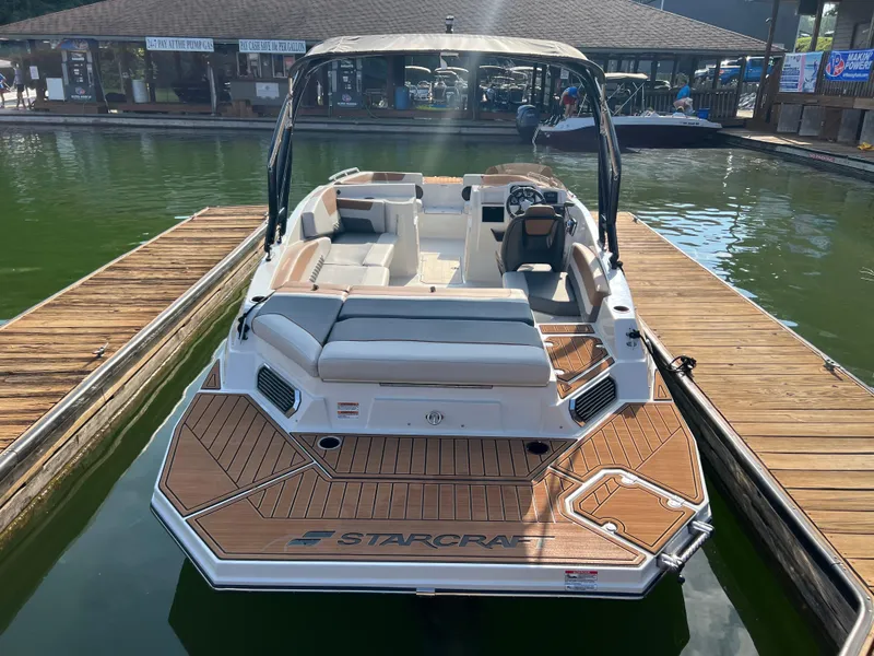 Slide: The Image of 2025 Starcraft SVX 231 IO boat docked, featuring spacious seating and sleek design. - 2