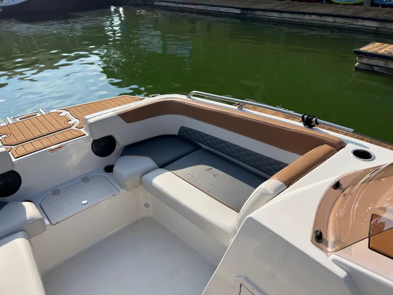 Slide: The Image of 2025 Starcraft SVX 231 IO boat interior with cushioned seating by the water. - 5