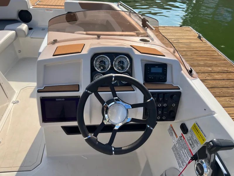 Slide: The Image of 2025 Starcraft SVX 231 IO boat dashboard with steering wheel and control panel. - 8