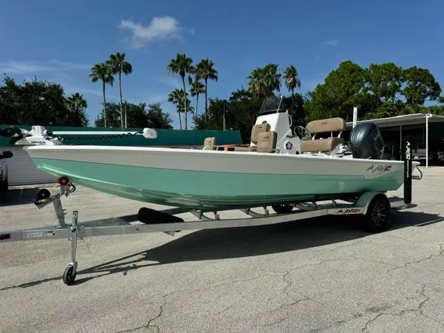 The Image of 2026 Avid 21 Fusion boat on trailer, parked outdoors with palm trees in background. - 1