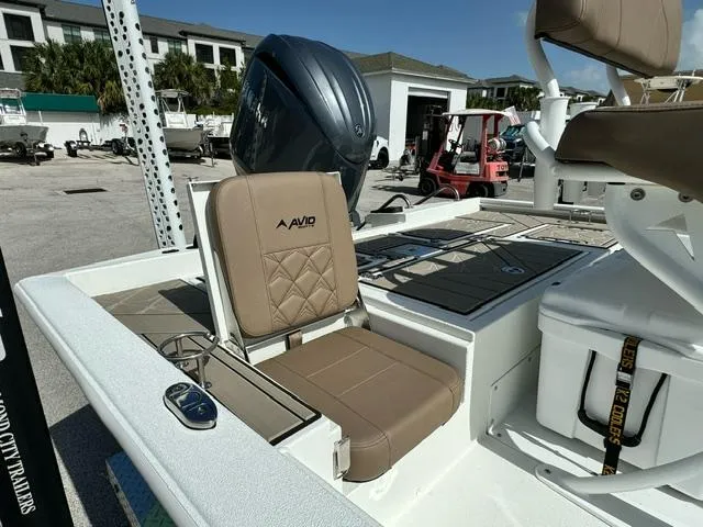 Slide: The Image of 2026 Avid 21 Fusion boat with tan seating and modern design in a marina setting. - 10