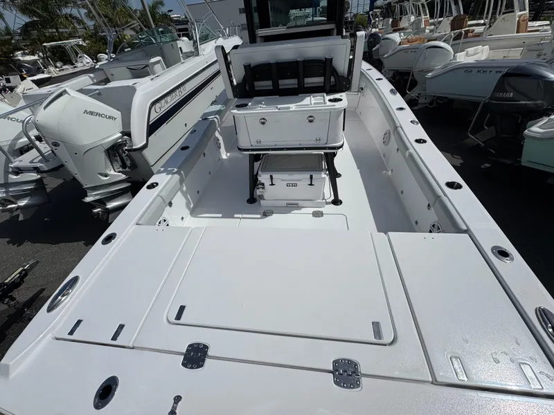 Slide: The Image of 2026 Blackfin 262 HB boat interior with seating and storage, displayed at a marina. - 14