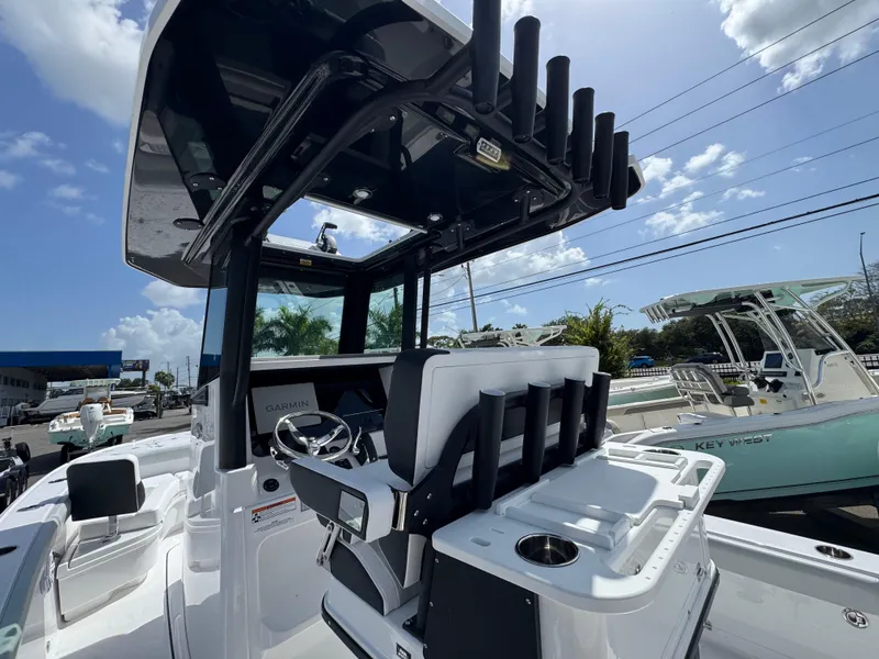 Slide: The Image of 2026 Blackfin 262 HB boat interior with steering console and rod holders under a sunny sky. - 19