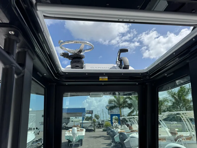 Slide: The Image of Interior view of 2026 Blackfin 262 HB boat with open sunroof and clear sky. - 24