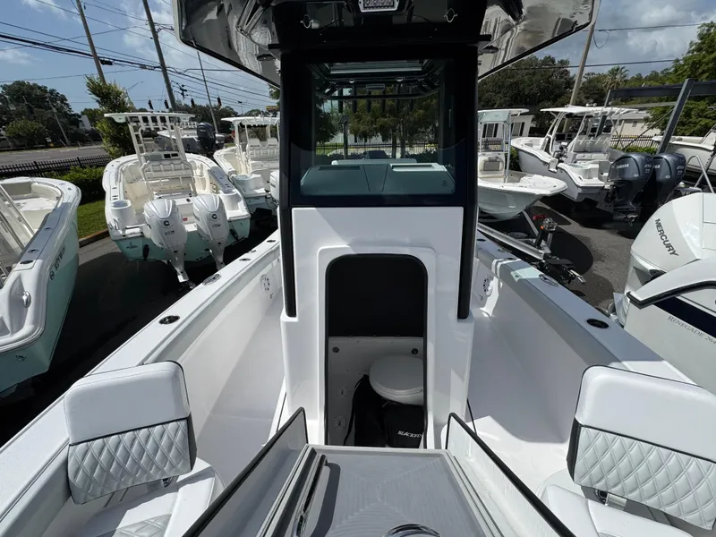 Slide: The Image of 2026 Blackfin 262 HB boat interior with seating and console, displayed in a marina. - 32