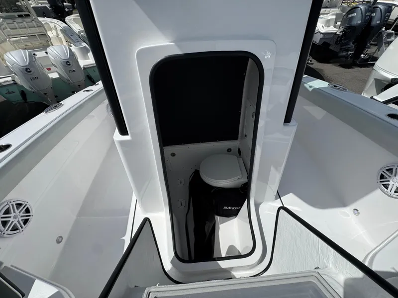 Slide: The Image of 2026 Blackfin 262 HB boat interior with compact marine toilet and storage area. - 33