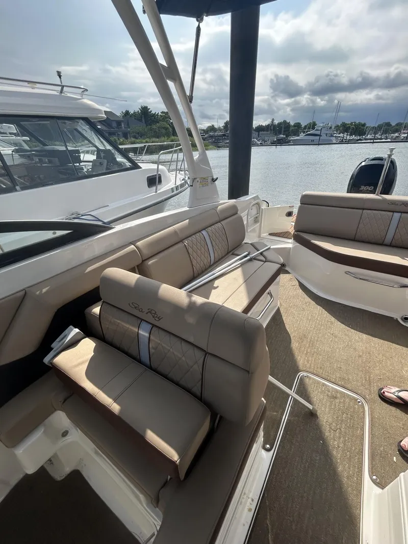 Slide: The Image of 2015 Sea Ray 270 Sundeck Outboard interior with beige seating, docked at marina. - 9