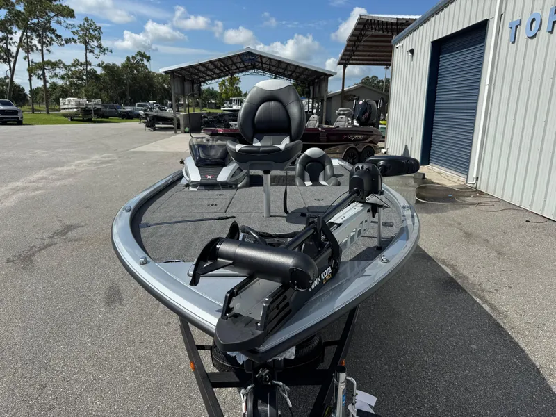 Slide: The Image of 2026 Vexus AVX1880 boat with trolling motor, parked outside a metal building. - 5