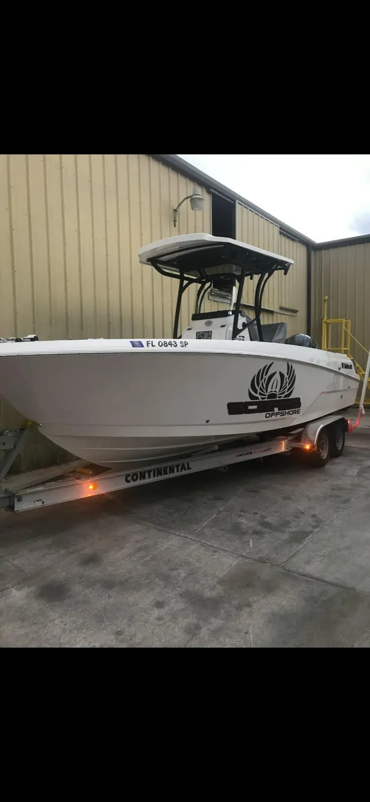 Slide: The Image of 2019 Wellcraft 242 Scarab Offshore boat on trailer, parked near a building. - 7