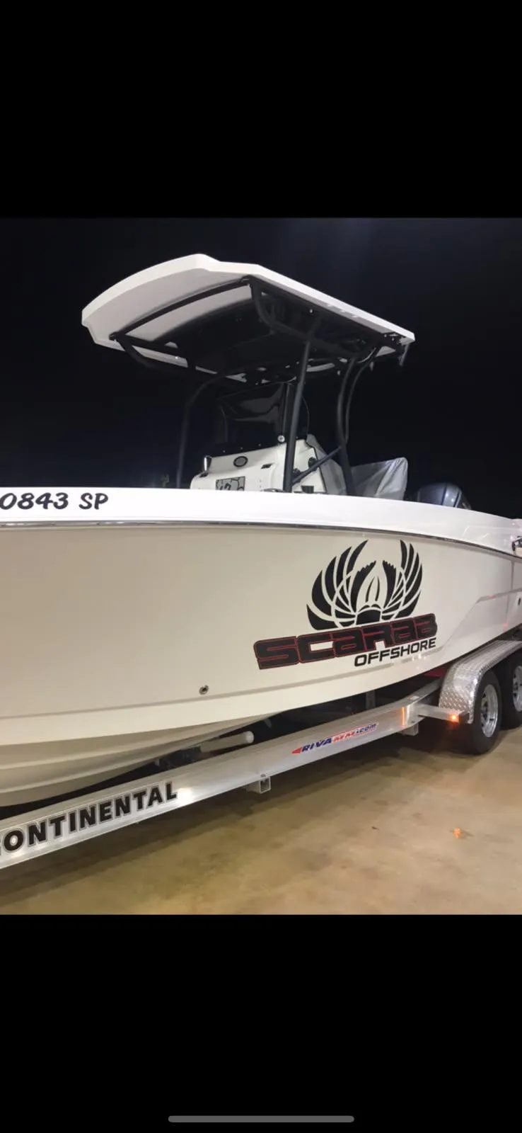 Slide: The Image of 2019 Wellcraft 242 Scarab Offshore boat on trailer, side view at night. - 9