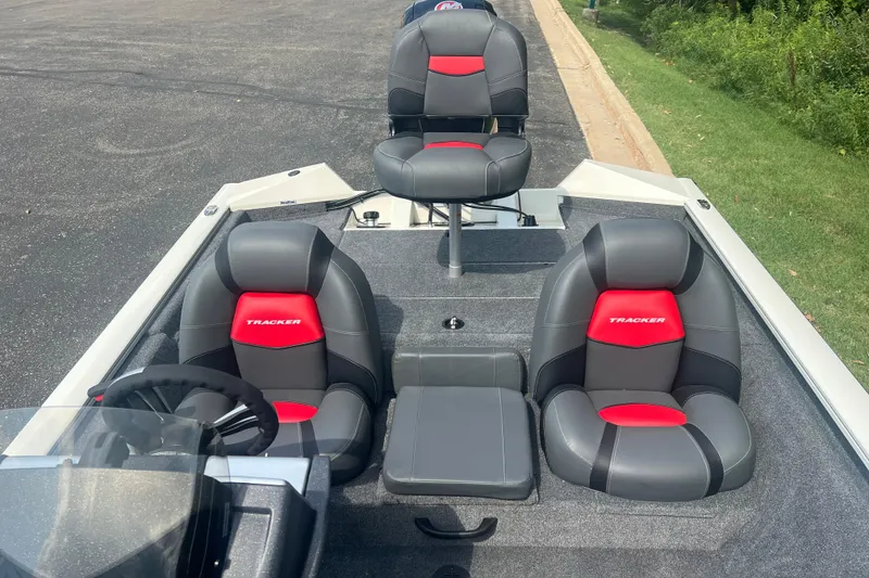 Slide: The Image of 2025 Tracker Pro Team 190 boat interior with gray and red seating, steering wheel, and carpeted deck. - 6