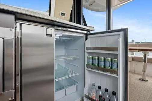 Slide: The Image of 2017 Regal 42 Grande Coupe yacht interior kitchen with microwave, cabinets, and countertop. - 12