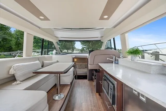 Slide: The Image of 2017 Regal 42 Grande Coupe yacht docked at a marina under a clear blue sky. - 7