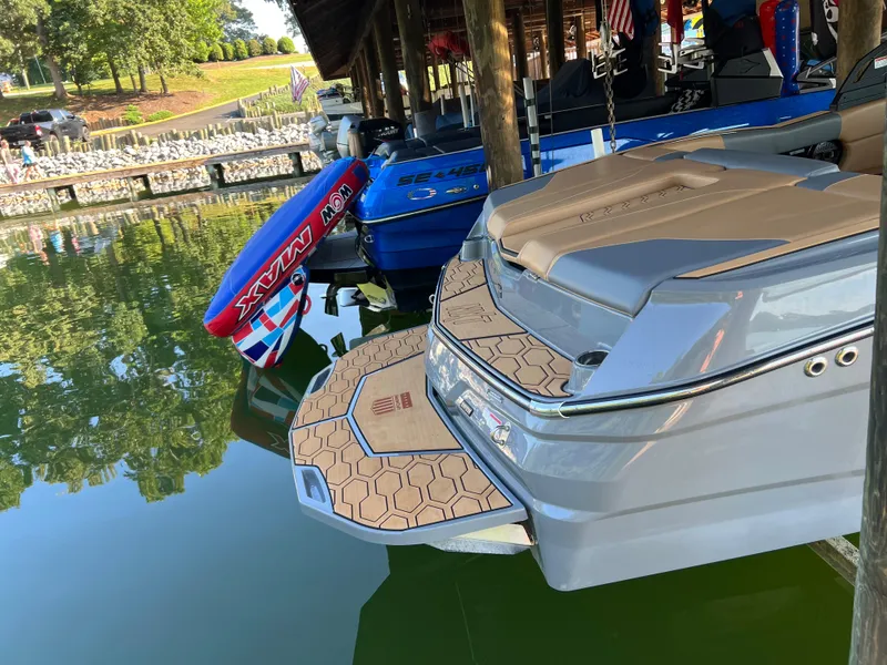 Slide: The Image of 2025 MasterCraft NXT23 boat docked with water sports equipment nearby. - 4