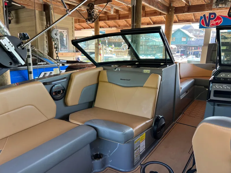 Slide: The Image of 2025 MasterCraft NXT23 boat interior with tan seating and modern design. - 9
