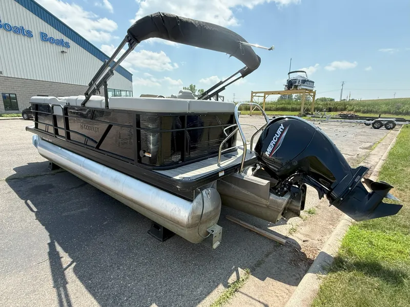 Slide: The Image of 2022 Godfrey Sweetwater 2186 C pontoon boat with Mercury outboard motor, parked outside. - 4
