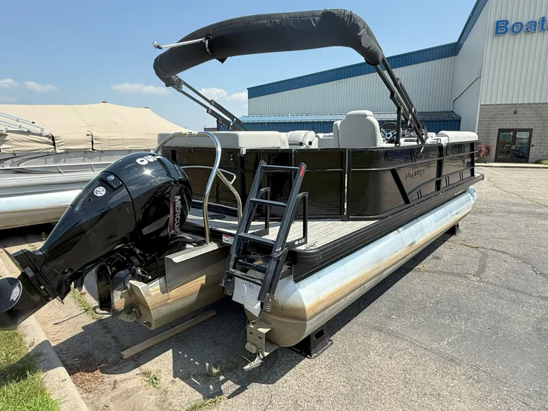 Slide: The Image of 2022 Godfrey Sweetwater 2186 C pontoon boat with Mercury outboard motor, parked outdoors. - 5