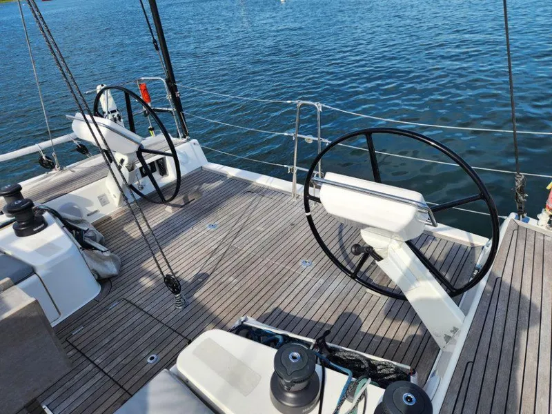 Slide: The Image of 2018 X-Yachts X4.9 sailboat deck with dual steering wheels on calm water. - 23