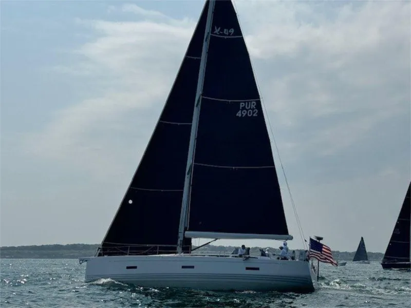 Slide: The Image of 2018 X-Yachts X4.9 sailing yacht with black sails on open water. - 3