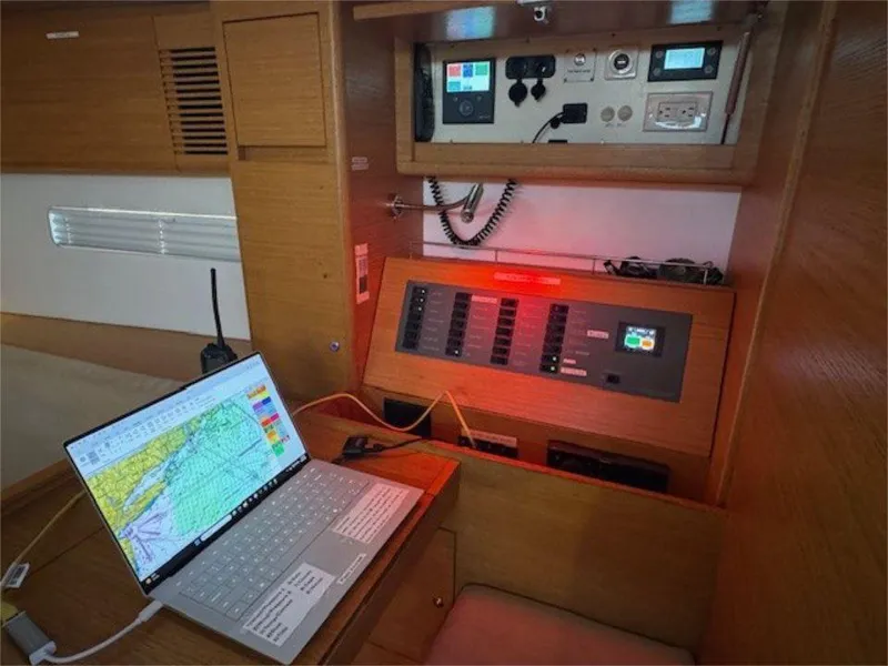 Slide: The Image of Navigation station inside 2018 X-Yachts X4.9, featuring control panels and a laptop with nautical charts. - 49