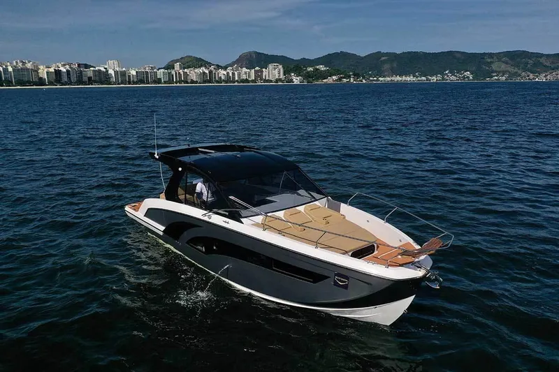 The Image of 2025 Hanover 387 Inboard boat cruising on open water with cityscape in background. - 0