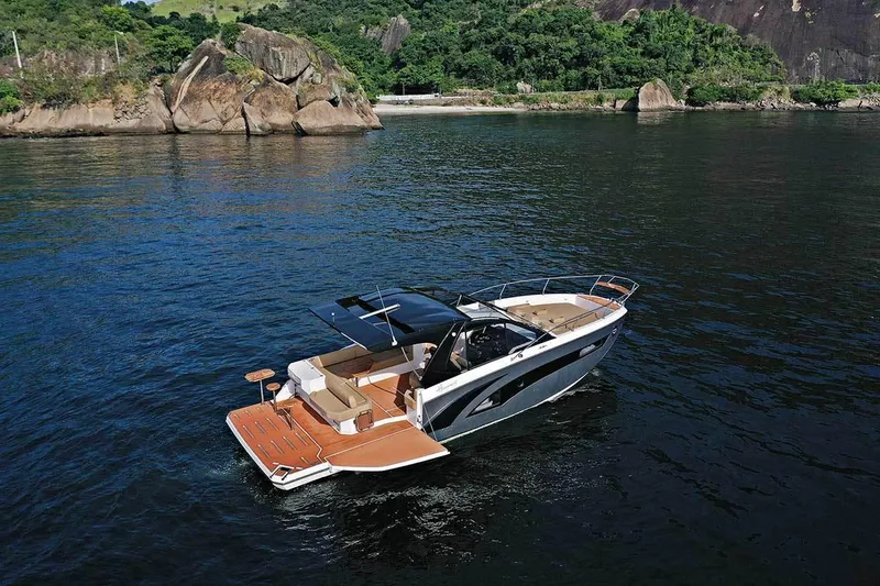 Slide: The Image of 2025 Hanover 387 Inboard boat cruising on a scenic lake with lush greenery. - 1