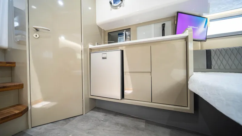 Slide: The Image of Interior of 2025 Hanover 387 Outboard boat with modern kitchenette and compact fridge. - 29