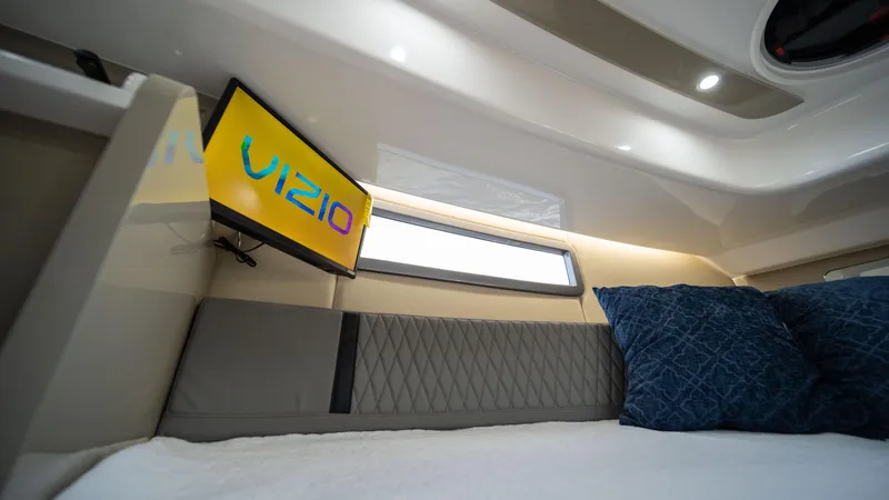 Slide: The Image of 2025 Hanover 387 Outboard cabin interior with Vizio TV and blue pillows. - 33