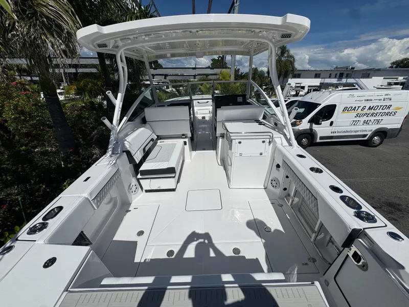 Slide: The Image of 2026 Blackfin 272 DC boat interior with seating and storage, parked near dealership. - 10