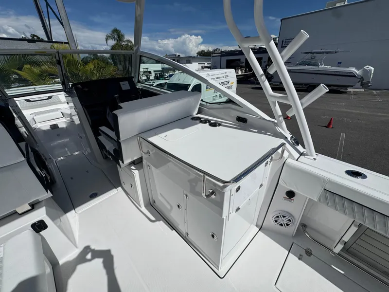 Slide: The Image of 2026 Blackfin 272 DC boat interior with seating and storage, docked under clear skies. - 18