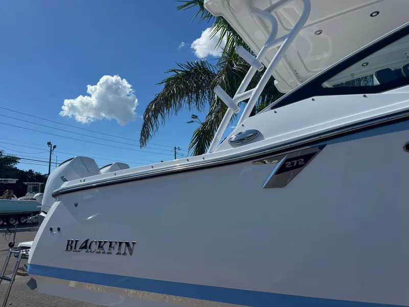 Slide: The Image of 2026 Blackfin 272 DC boat under clear blue sky with palm tree. - 4