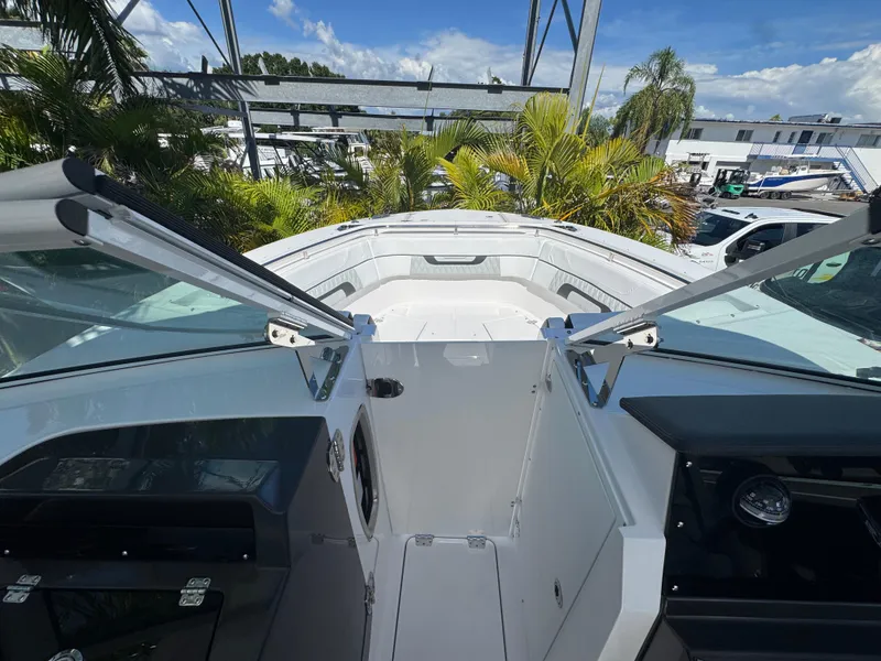 Slide: The Image of 2026 Blackfin 272 DC boat interior with open deck and lush greenery background. - 40