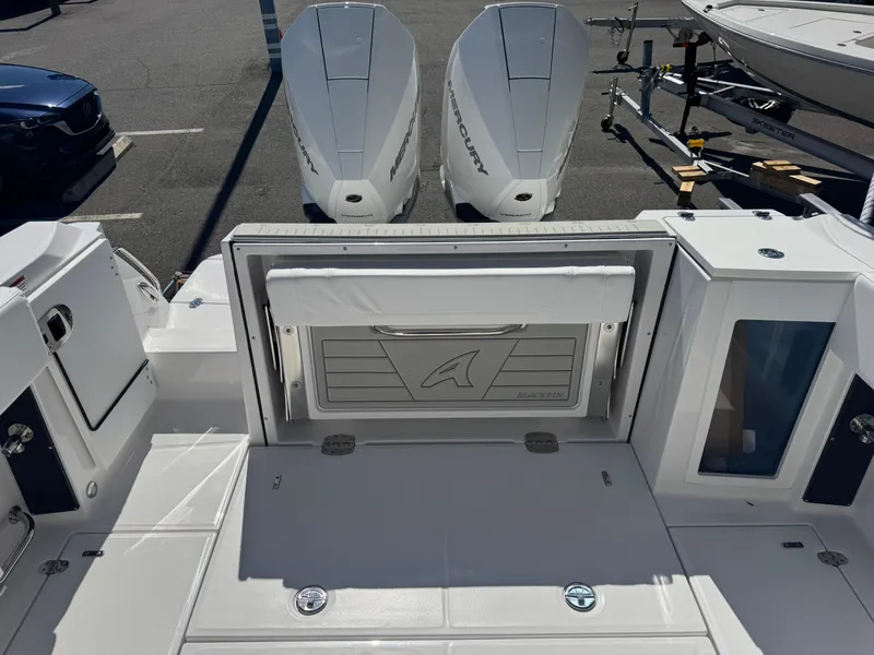 Slide: The Image of 2026 Blackfin 272 DC boat with dual Mercury outboard engines, docked in a marina. - 46