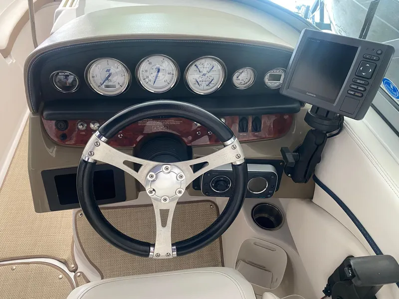 Slide: The Image of 2008 Four Winns H260 boat dashboard with steering wheel and navigation system. - 11