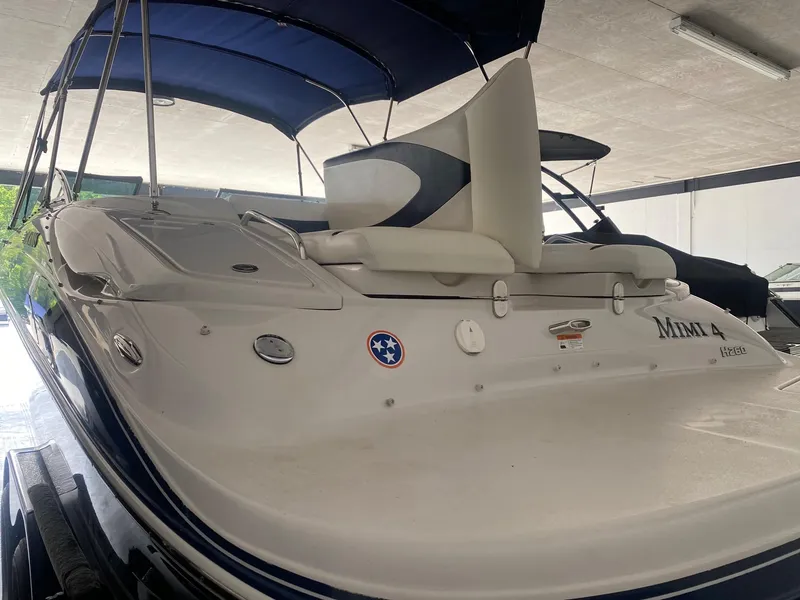 Slide: The Image of 2008 Four Winns H260 boat with blue canopy in a covered storage area. - 6