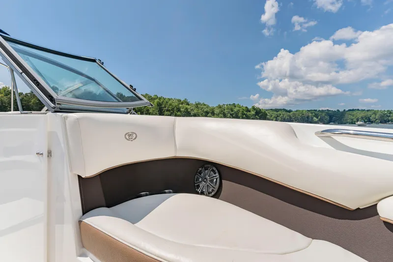 Slide: The Image of 2016 Cobalt 200 boat interior with white seating, open windshield, and scenic lake view. - 16