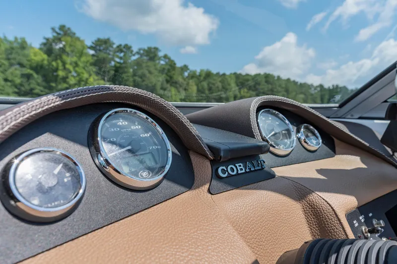 Slide: The Image of Dashboard of 2016 Cobalt 200 boat with gauges and logo, under blue sky. - 19