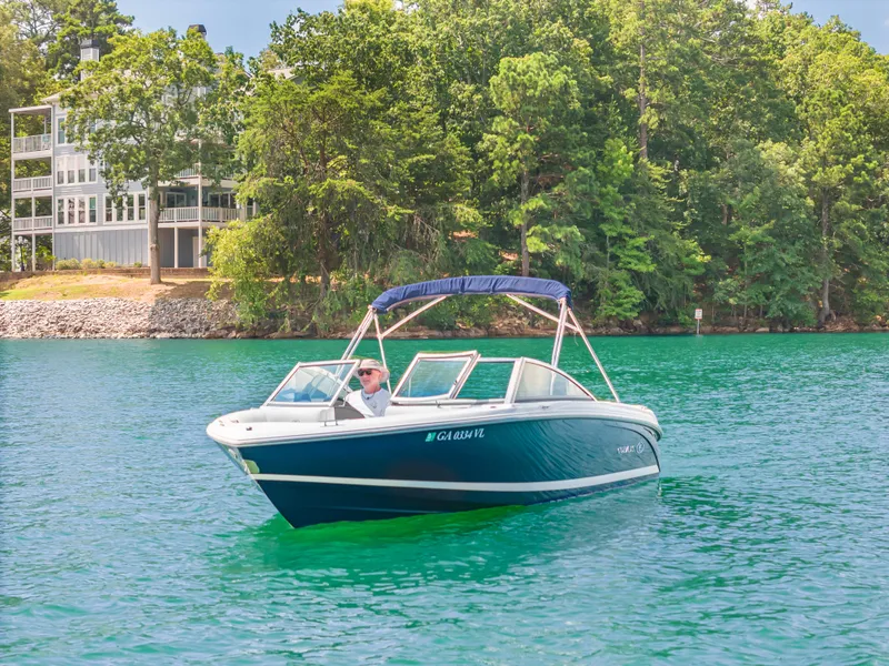 Slide: The Image of 2016 Cobalt 200 boat on a serene lake with lush green trees. - 4