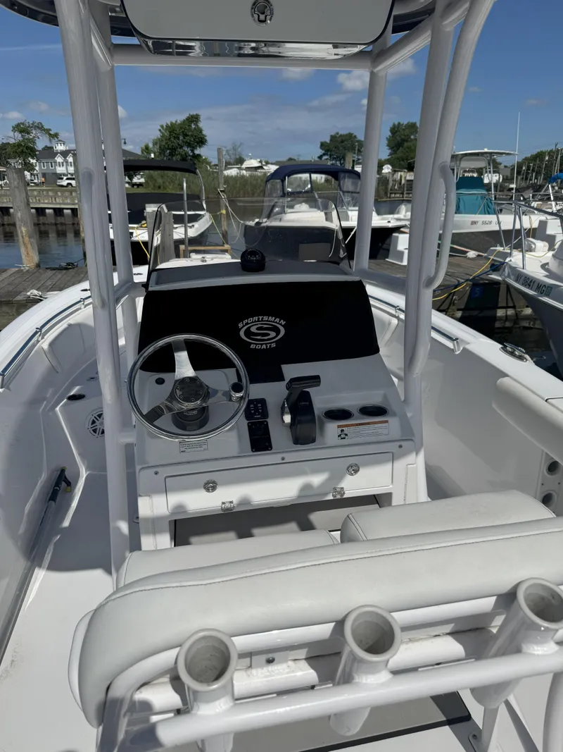 Slide: The Image of 2022 Sportsman Open 232 Center Console boat interior at a marina. - 2