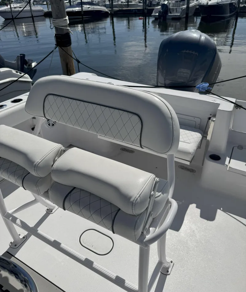 Slide: The Image of 2022 Sportsman Open 232 Center Console boat interior with white cushioned seating. - 6