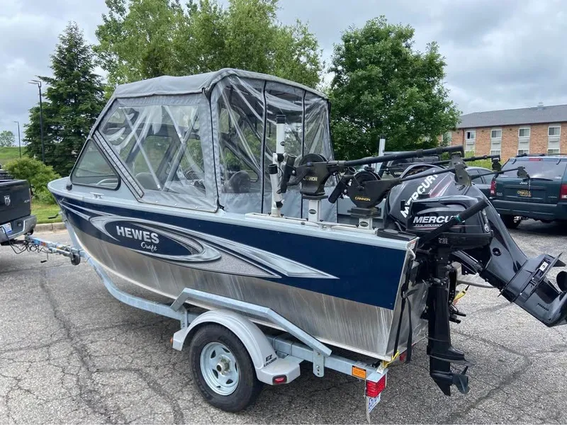 Slide: The Image of 2018 Hewescraft 160 Sportsman boat on trailer, featuring Mercury outboard motor. - 2